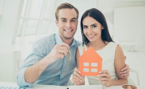 Happy couple holding keys to a new house